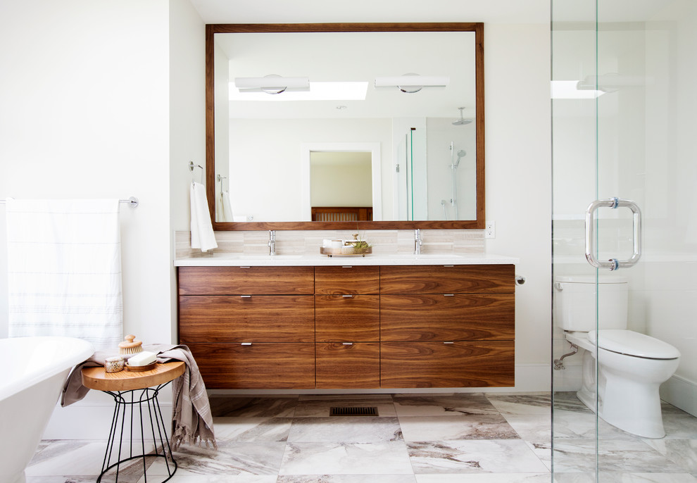 Contemporary master bathroom in Vancouver with flat-panel cabinets, a freestanding tub, a corner shower, a two-piece toilet, beige tile, porcelain tile, white walls, porcelain floors, an undermount sink, engineered quartz benchtops, a hinged shower door, medium wood cabinets and multi-coloured floor.