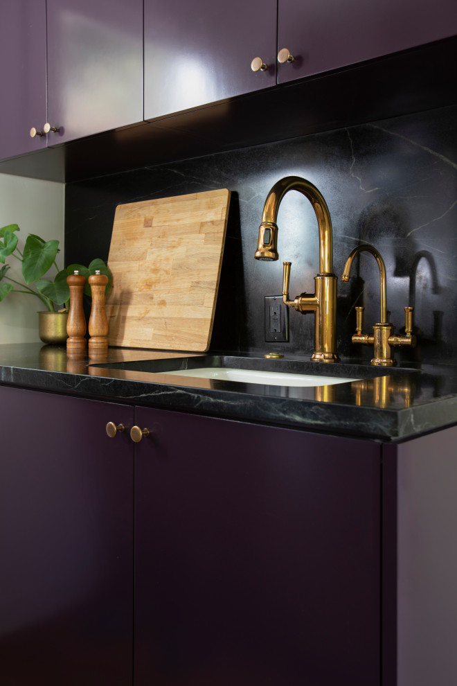 Exempel på ett litet klassiskt svart svart kök, med en undermonterad diskho, släta luckor, lila skåp, marmorbänkskiva, svart stänkskydd, stänkskydd i marmor, rostfria vitvaror, mellanmörkt trägolv och brunt golv
