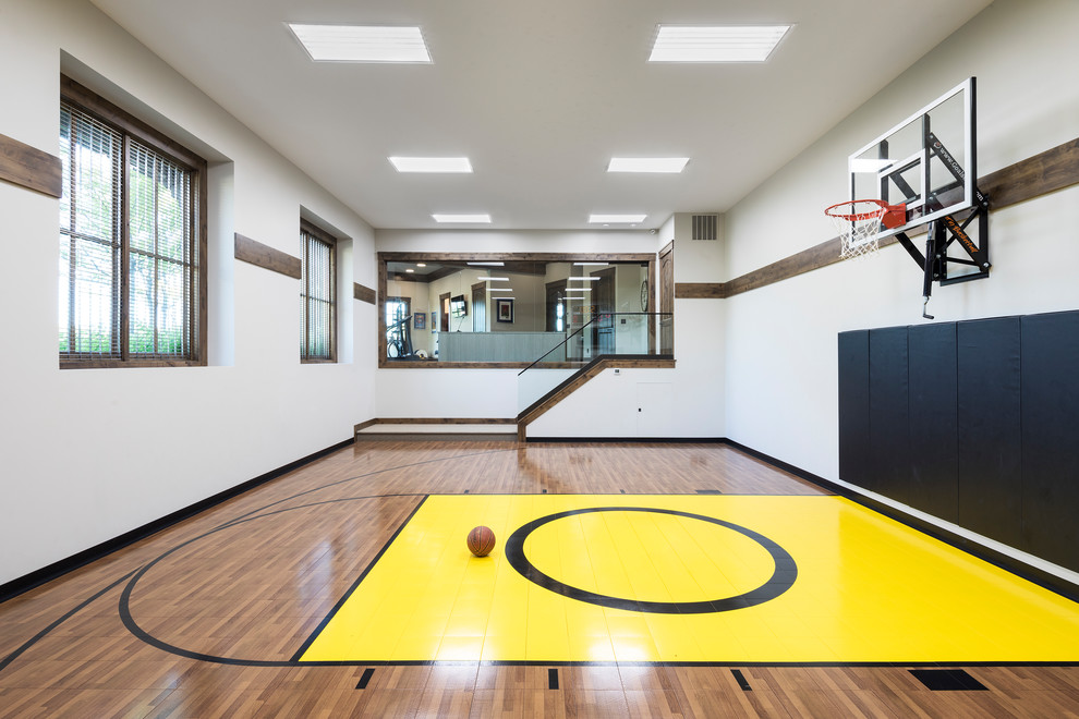 Photo of a country indoor sport court in Minneapolis with white walls, medium hardwood floors and brown floor.