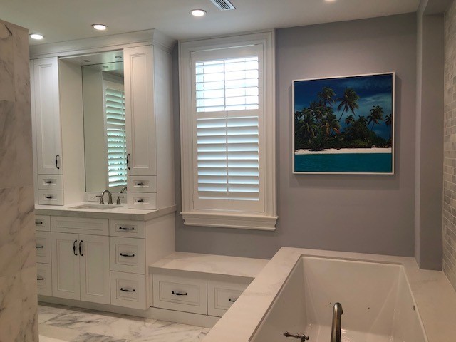 Example of a transitional bathroom design with white cabinets and quartz countertops