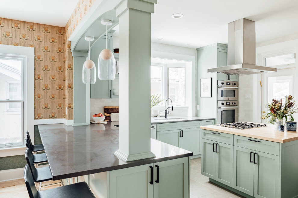 Mid-sized transitional l-shaped eat-in kitchen in Salt Lake City with shaker cabinets, green cabinets, solid surface benchtops, stainless steel appliances, cement tiles, with island, grey floor, grey benchtop, an undermount sink, white splashback and window splashback.