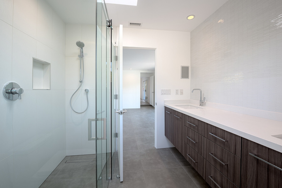 Design ideas for a large midcentury master bathroom in Other with flat-panel cabinets, medium wood cabinets, a curbless shower, a one-piece toilet, white tile, stone tile, white walls, porcelain floors, an undermount sink and engineered quartz benchtops.