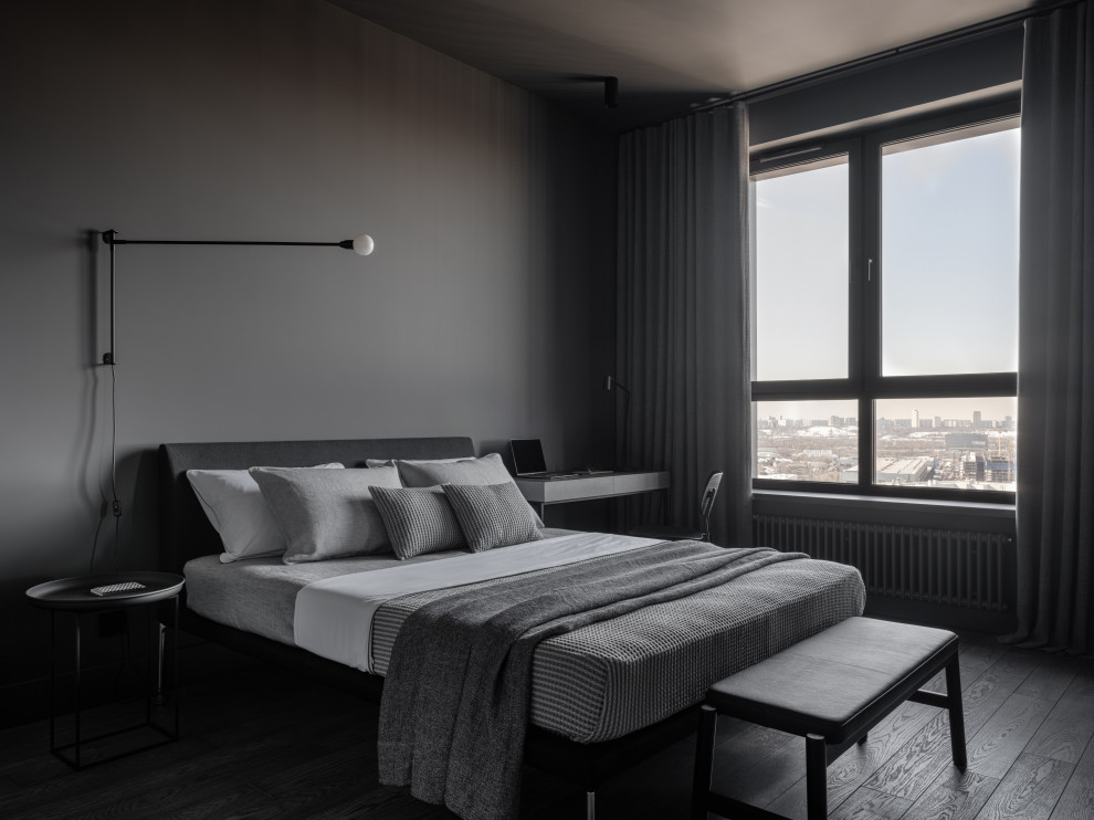 На фото: хозяйская, серо-белая спальня среднего размера в стиле лофт с серыми стенами, паркетным полом среднего тона, серым полом и рабочим местом с