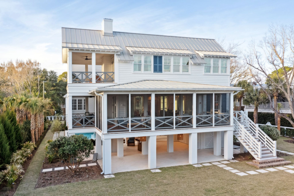 Historic Sea Cabins - Sullivan's Island beach house, highlighting the restored, existing historic sea cabin. Exterior is painted cedar lap siding with a hand-crimped metal roof in a light grey. The second story will offer ocean views. Shellstone pavers line the ground floor and walkways