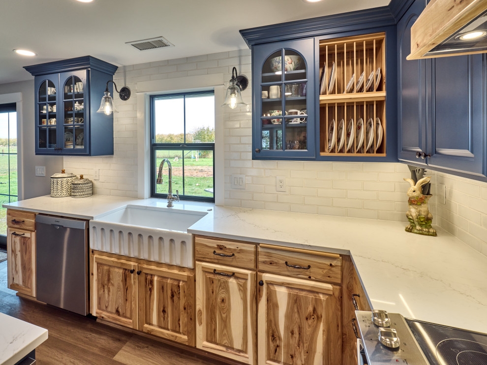 Inspiration for a mid-sized country l-shaped eat-in kitchen in Other with a farmhouse sink, beaded inset cabinets, light wood cabinets, quartz benchtops, white splashback, brick splashback, stainless steel appliances, vinyl floors, with island, grey floor and white benchtop.