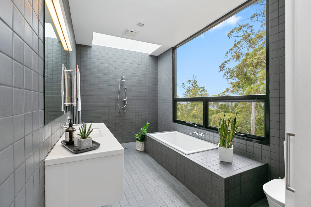 Inspiration for a large contemporary master bathroom in Hobart with a drop-in tub, gray tile, white benchtops, white cabinets, a curbless shower, an undermount sink, grey floor and an open shower.