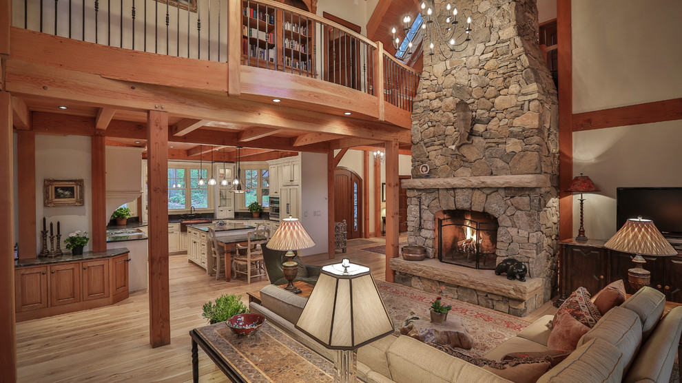 This is an example of an arts and crafts open concept living room in Burlington with grey walls, light hardwood floors, a standard fireplace and a stone fireplace surround.
