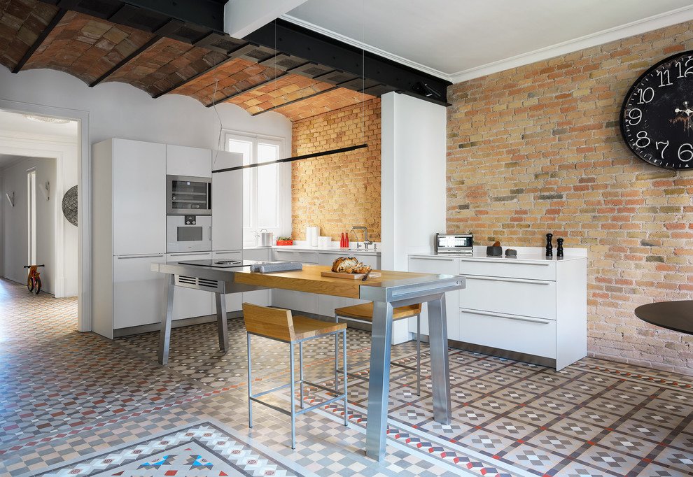 Inspiration for a large mediterranean u-shaped kitchen in Other with flat-panel cabinets, white cabinets, stainless steel appliances, with island, ceramic floors, multi-coloured floor, red splashback and brick splashback.