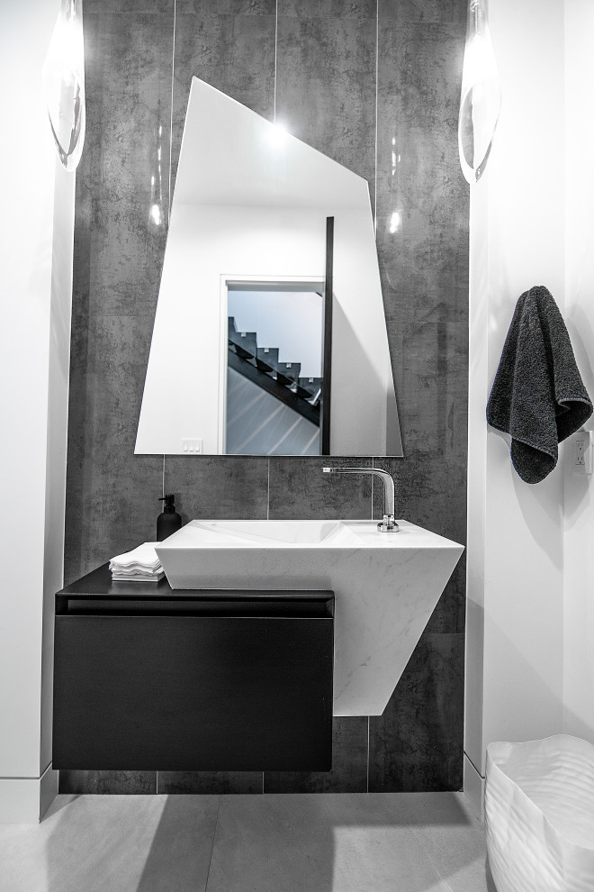 Contemporary powder room in San Francisco with flat-panel cabinets, black cabinets, grey walls, grey floor and black benchtops.