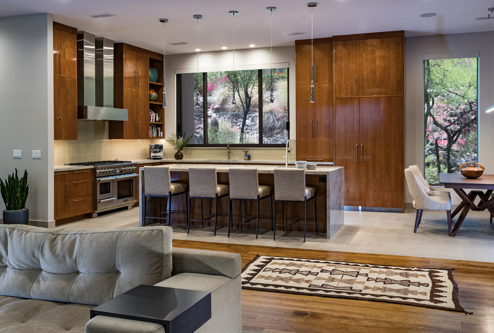 This is an example of a large contemporary l-shaped eat-in kitchen in Phoenix with a single-bowl sink, flat-panel cabinets, medium wood cabinets, quartzite benchtops, beige splashback, glass tile splashback, panelled appliances, porcelain floors, with island, beige floor and beige benchtop.