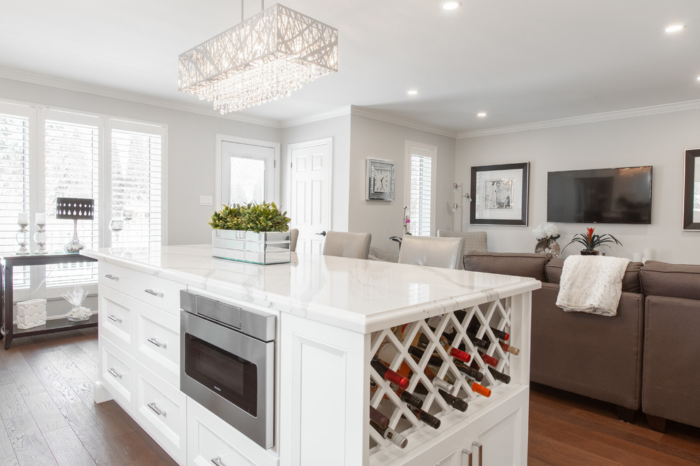Enclosed kitchen - large transitional l-shaped medium tone wood floor and brown floor enclosed kitchen idea with an undermount sink, recessed-panel cabinets, white cabinets, quartz countertops, gray backsplash, ceramic backsplash, stainless steel appliances, an island and white countertops
