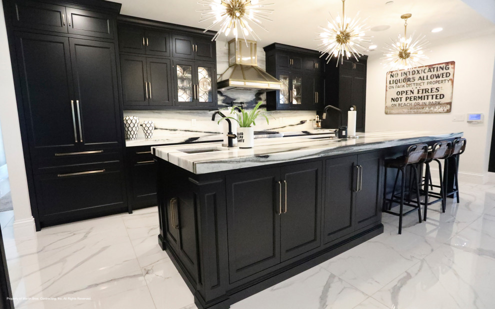 Mid-sized transitional porcelain tile and white floor open concept kitchen photo with an undermount sink, recessed-panel cabinets, black cabinets, marble countertops, marble backsplash, stainless steel appliances and an island
