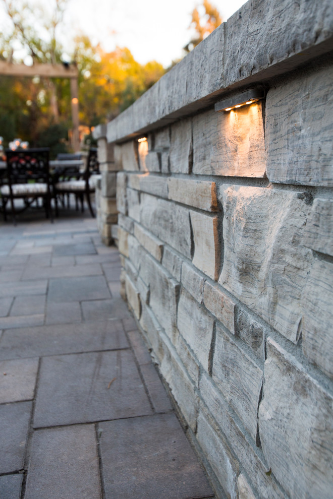 This is an example of a transitional backyard stone water fountain landscape in Omaha.