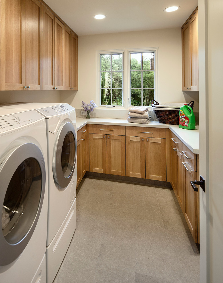 Inspiration for a mediterranean u-shaped laundry room in Santa Barbara with shaker cabinets, light wood cabinets, a side-by-side washer and dryer and white benchtop.