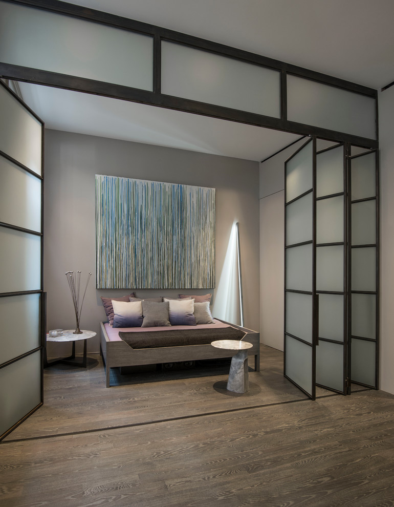 Bedroom - mid-sized modern loft-style medium tone wood floor bedroom idea in New York with gray walls