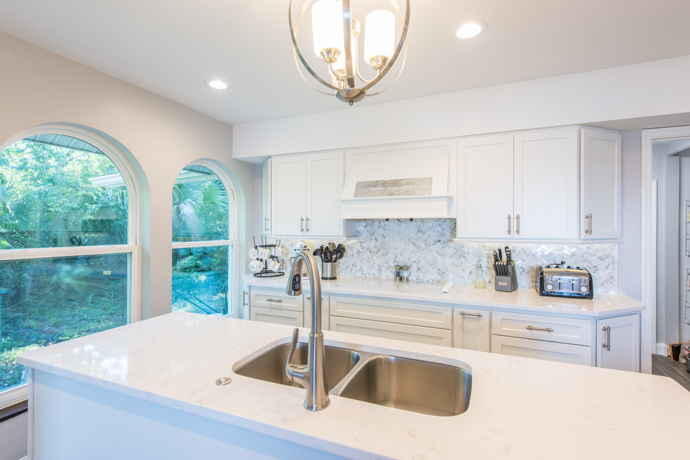 Eat-in kitchen - large transitional u-shaped porcelain tile and brown floor eat-in kitchen idea with an undermount sink, shaker cabinets, white cabinets, quartz countertops, white backsplash, marble backsplash, stainless steel appliances and two islands