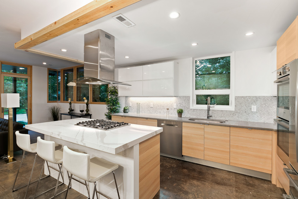 Photo of a contemporary open plan kitchen in Denver with an undermount sink, flat-panel cabinets, white cabinets, grey splashback, stainless steel appliances, concrete floors, with island and brown floor.