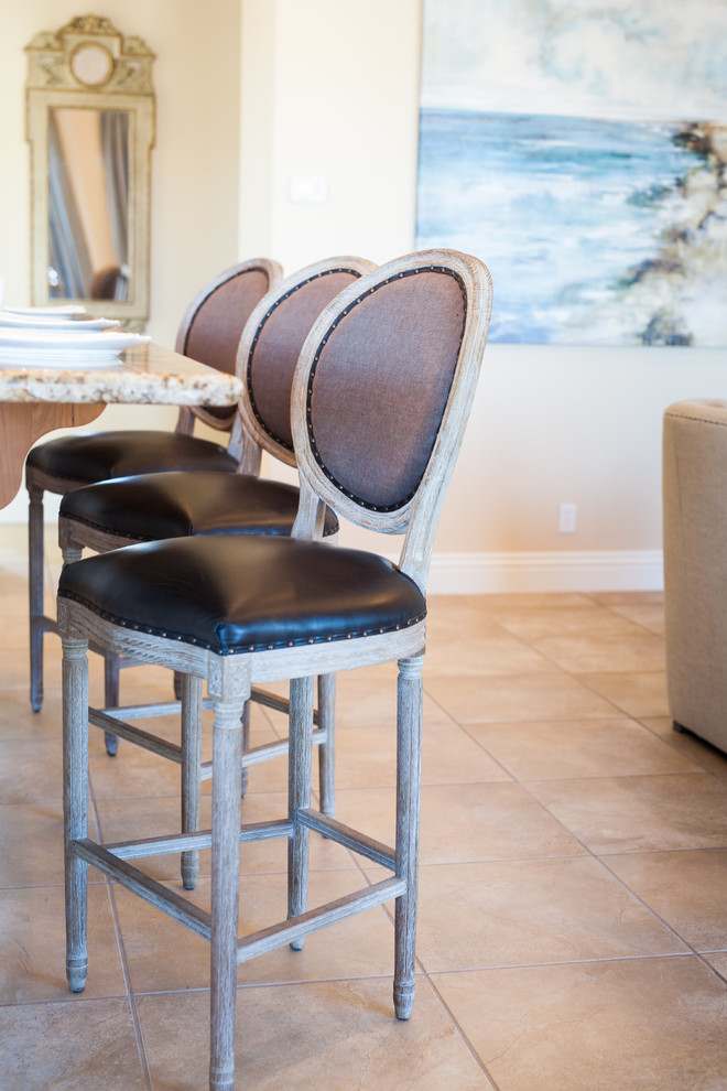 This is an example of a mid-sized beach style u-shaped open plan kitchen in Las Vegas with an undermount sink, shaker cabinets, medium wood cabinets, granite benchtops, multi-coloured splashback, stone tile splashback, stainless steel appliances, terra-cotta floors, with island and brown floor.