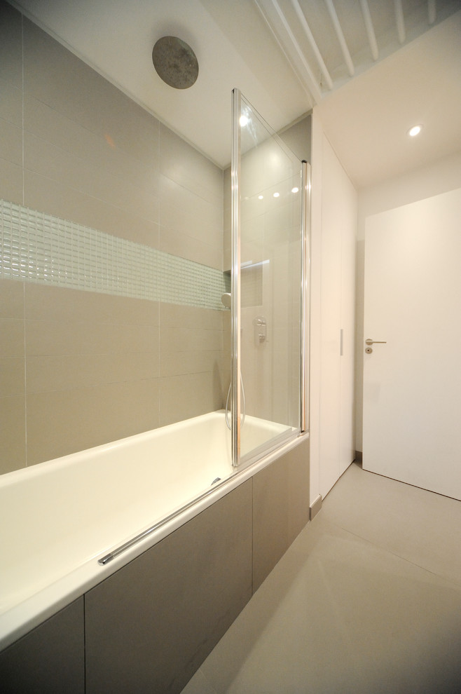 This is an example of a small contemporary master bathroom in Paris with an undermount tub and beige walls.