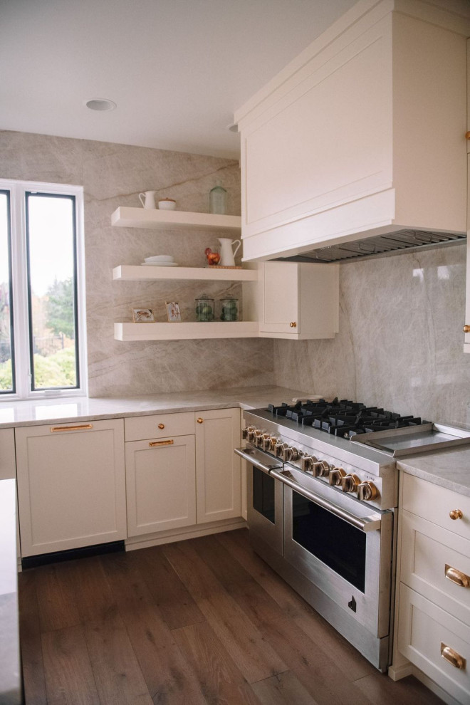 Modern inredning av ett stort grå grått kök, med en undermonterad diskho, luckor med infälld panel, vita skåp, granitbänkskiva, grått stänkskydd, rostfria vitvaror, mellanmörkt trägolv, en köksö och flerfärgat golv