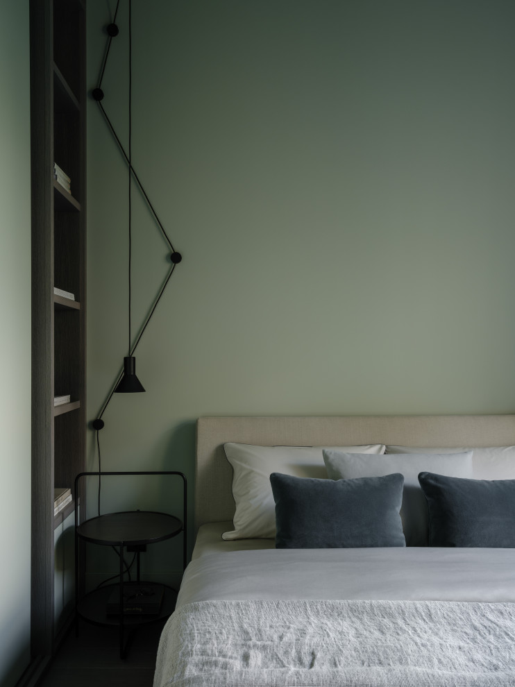 На фото: хозяйская спальня среднего размера в современном стиле с зелеными стенами, темным паркетным полом, черным полом и акцентной стеной с