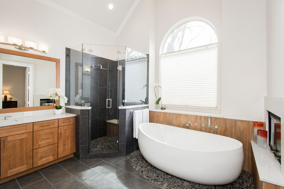 Inspiration for a mid-sized timeless master gray tile and porcelain tile porcelain tile and gray floor freestanding bathtub remodel in Dallas with flat-panel cabinets, brown cabinets, a one-piece toilet, gray walls, an undermount sink, quartzite countertops, a hinged shower door and white countertops