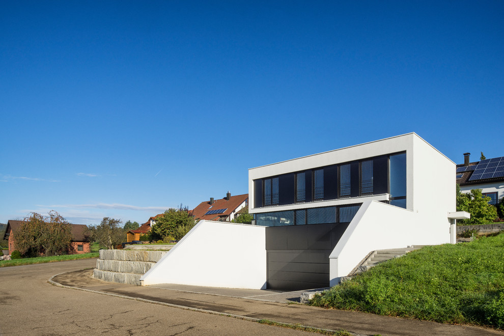 This is an example of a mid-sized contemporary two-storey white exterior in Stuttgart with mixed siding and a flat roof.