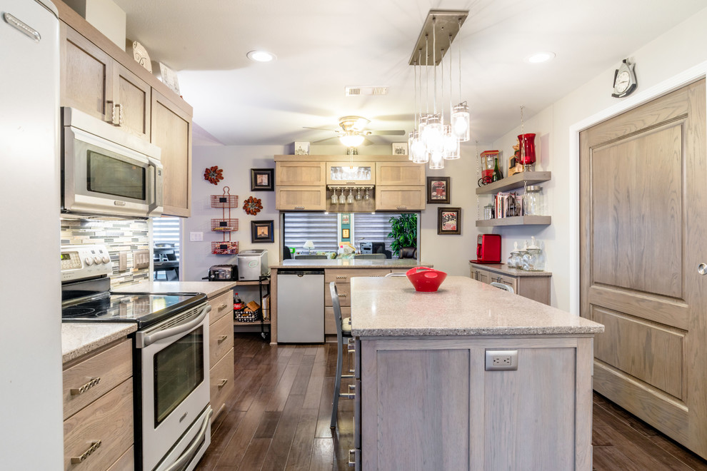 Inspiration for a mid-sized transitional u-shaped medium tone wood floor enclosed kitchen remodel in Miami with a farmhouse sink, shaker cabinets, gray cabinets, quartz countertops, gray backsplash, glass tile backsplash, white appliances and an island