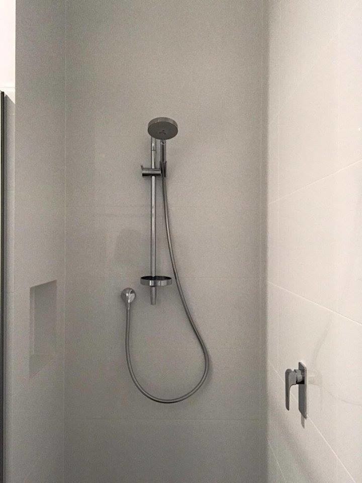 Photo of a small 3/4 bathroom in Adelaide with furniture-like cabinets, white cabinets, a corner shower, a one-piece toilet, gray tile, porcelain tile, white walls, porcelain floors and wood benchtops.