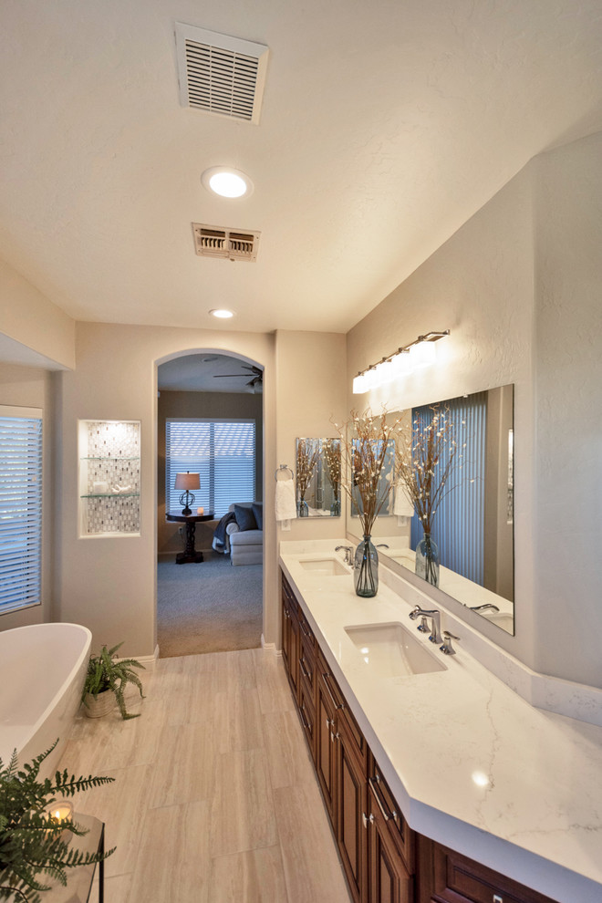 Mid-sized contemporary master bathroom in Phoenix with raised-panel cabinets, brown cabinets, a freestanding tub, a corner shower, white tile, an undermount sink, engineered quartz benchtops, a hinged shower door and brown benchtops.