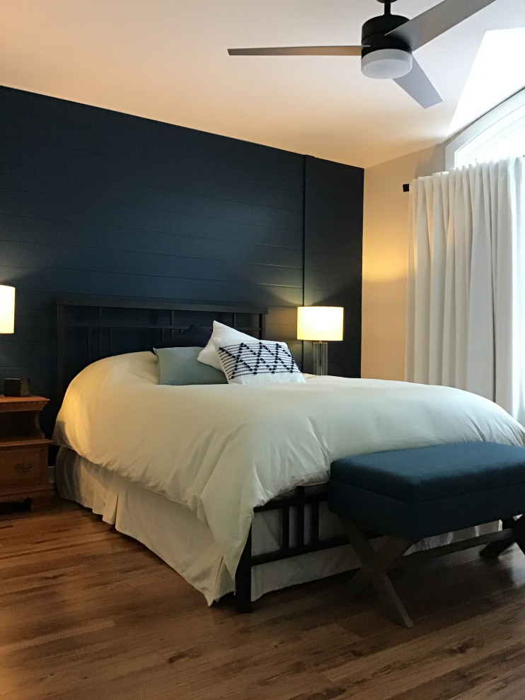 Mittelgroßes Modernes Hauptschlafzimmer mit blauer Wandfarbe, Laminat und Holzdielenwänden in Ottawa