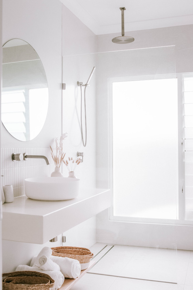 This is an example of a contemporary bathroom in Gold Coast - Tweed with white walls, a floating vanity, a curbless shower, white tile, a vessel sink, white floor, an open shower, white benchtops and a single vanity.