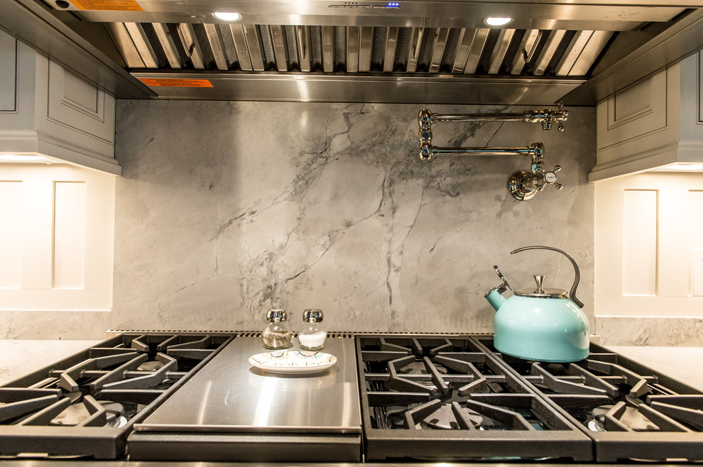 Mid-sized trendy single-wall medium tone wood floor open concept kitchen photo in Charleston with a farmhouse sink, shaker cabinets, marble countertops, white backsplash, stainless steel appliances, two islands, beige cabinets and stone slab backsplash