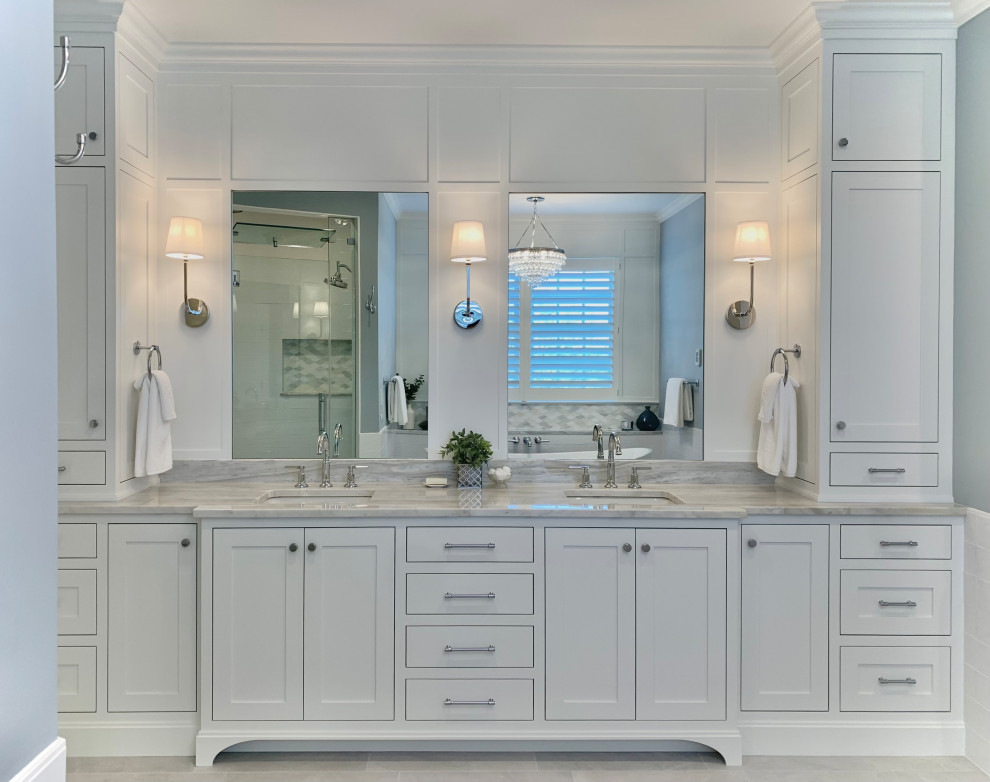 Inredning av ett klassiskt en-suite badrum, med skåp i shakerstil, vita skåp, ett fristående badkar, en dubbeldusch, vit kakel, porslinskakel, blå väggar, klinkergolv i porslin, ett undermonterad handfat, marmorbänkskiva, grått golv och dusch med gångjärnsdörr