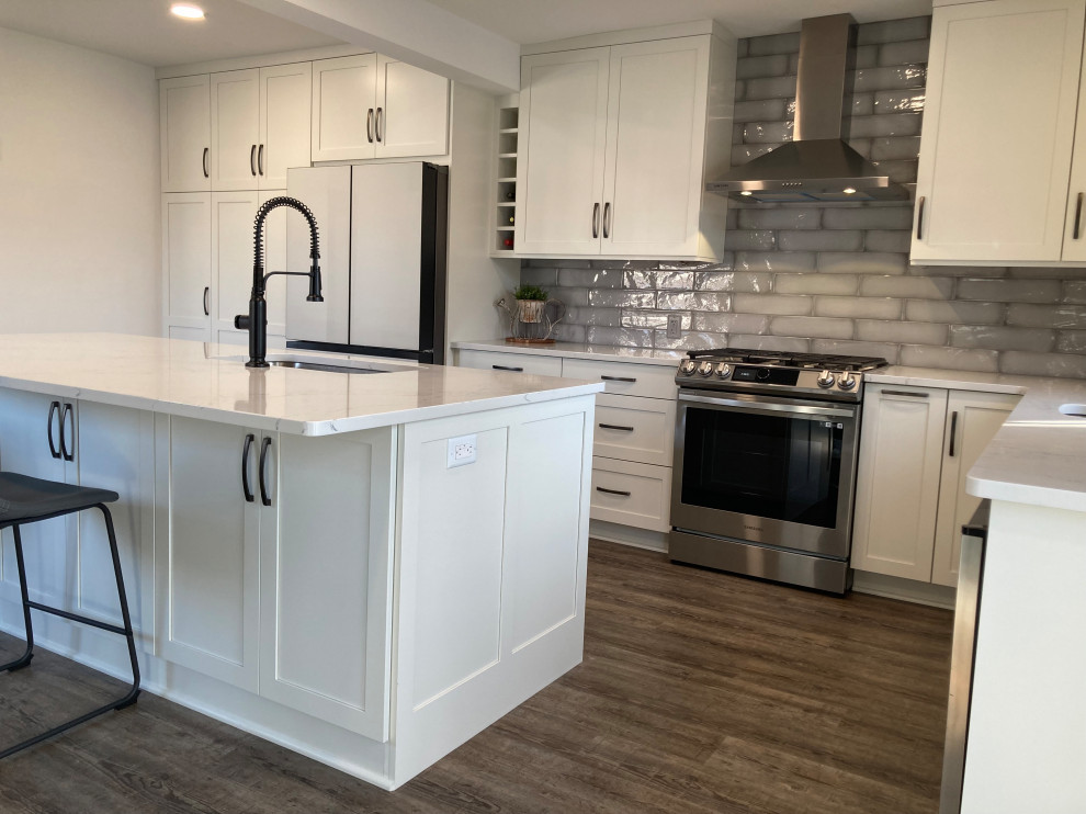 Mid-sized contemporary l-shaped eat-in kitchen in Other with shaker cabinets, white cabinets, quartz benchtops, with island and white benchtop.
