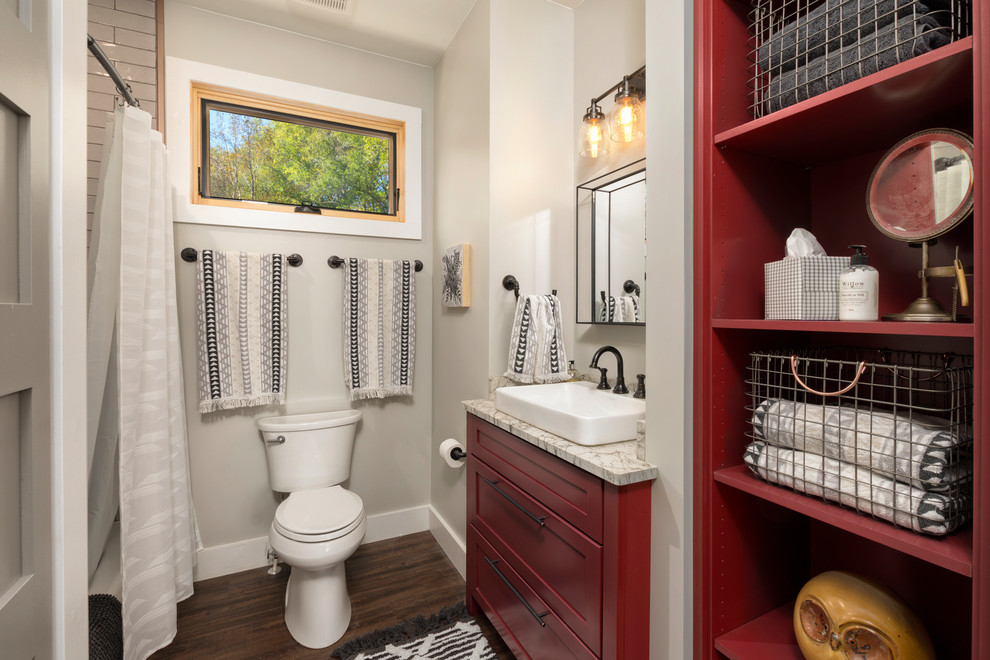 Country bathroom in Other with shaker cabinets, red cabinets, a one-piece toilet, grey walls, dark hardwood floors, a vessel sink and multi-coloured benchtops.
