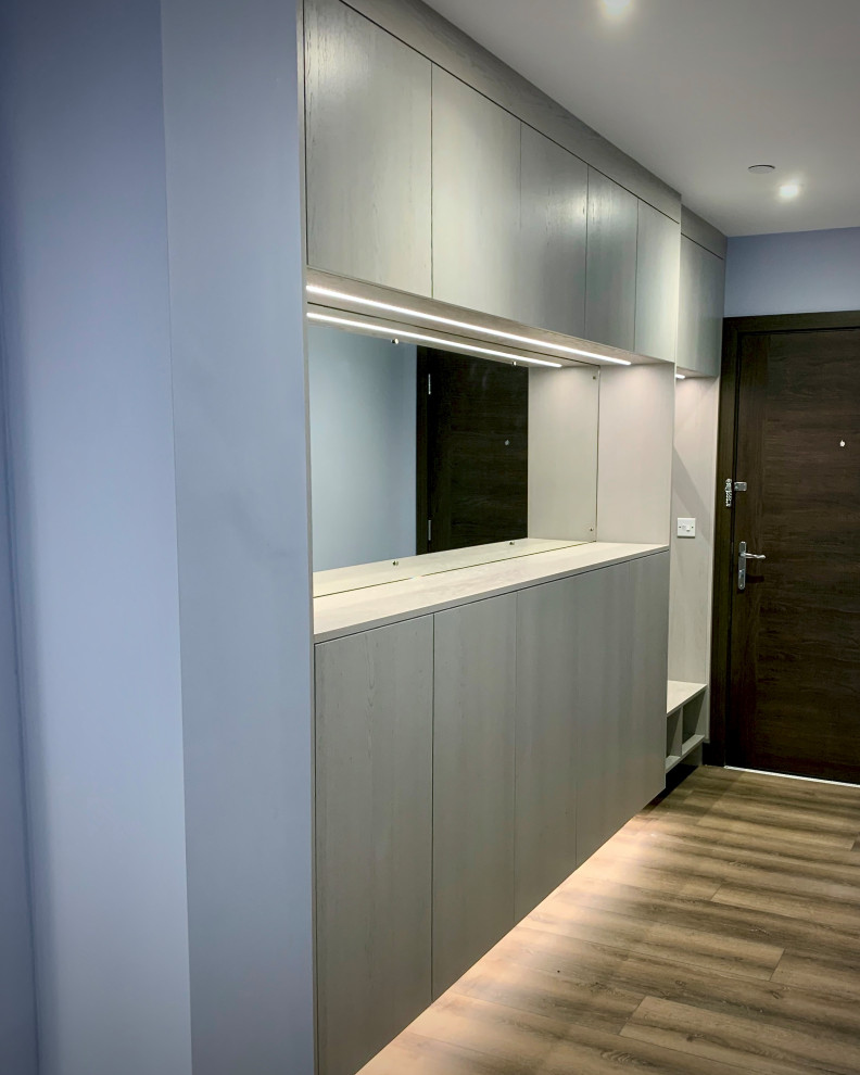 Hallway - large contemporary laminate floor and brown floor hallway idea in Essex with blue walls