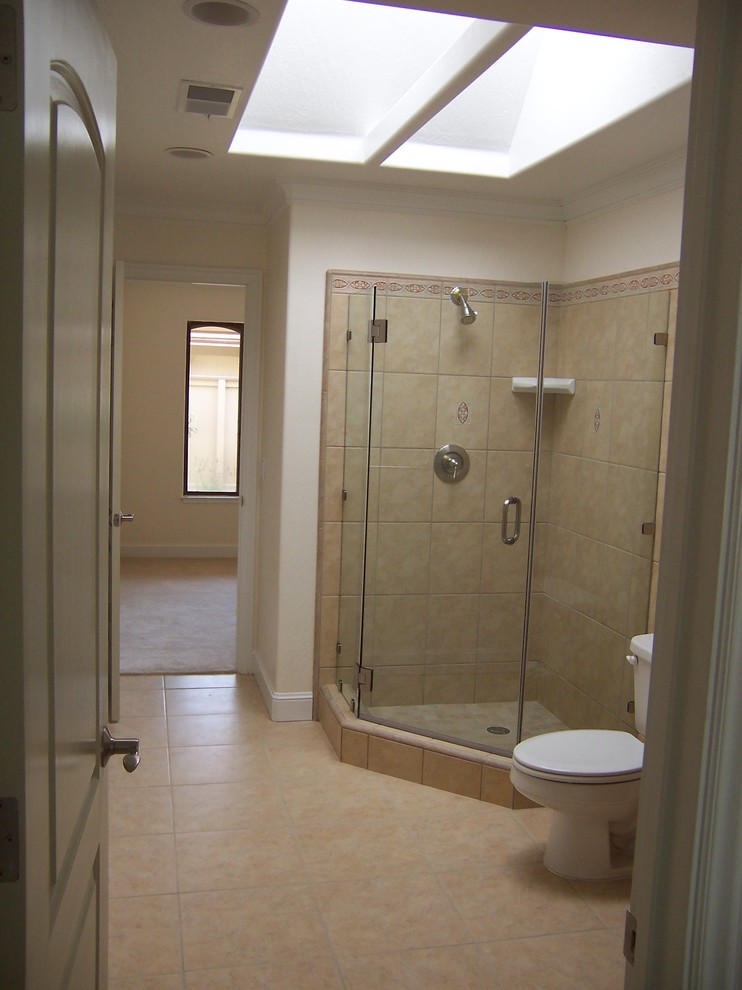 This is an example of a mid-sized transitional master bathroom in San Francisco with shaker cabinets, white cabinets, a two-piece toilet, beige tile, porcelain tile, beige walls, porcelain floors, a drop-in sink and tile benchtops.
