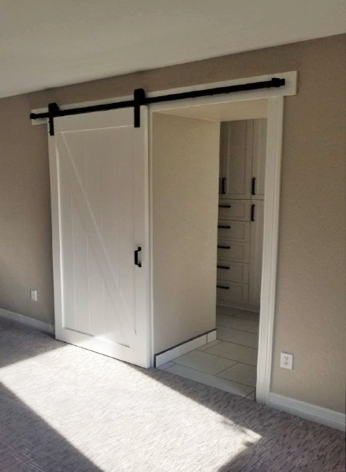Inspiration for a mid-sized modern gender-neutral walk-in wardrobe in Denver with recessed-panel cabinets, white cabinets, porcelain floors and white floor.