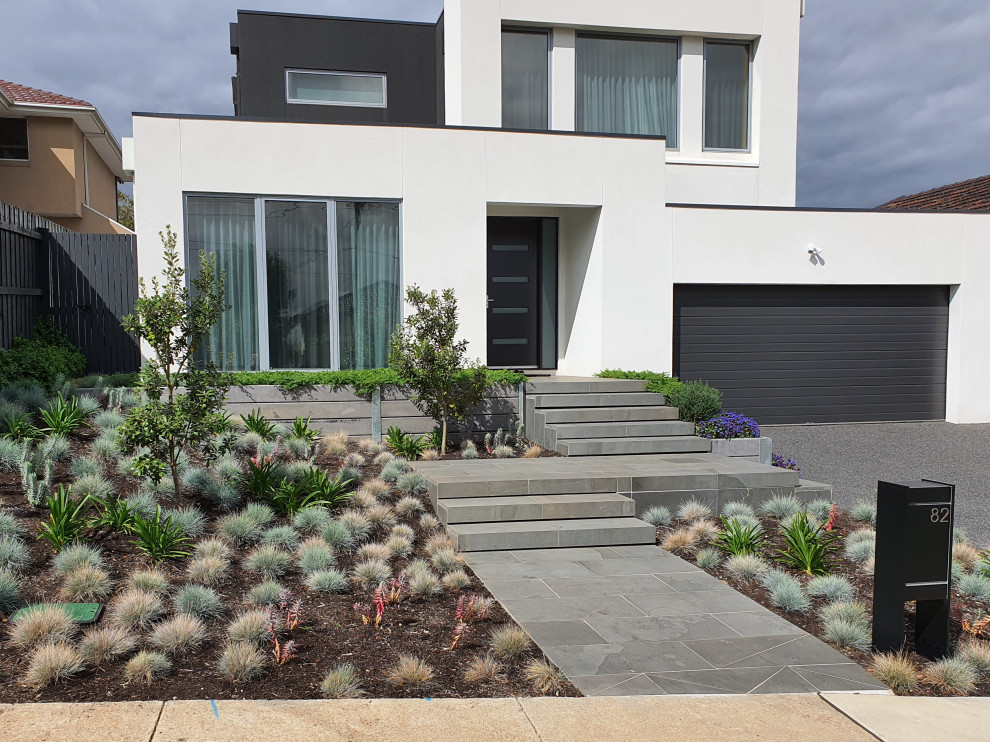 Design ideas for a large modern front yard full sun formal garden for spring in Melbourne with a garden path and natural stone pavers.