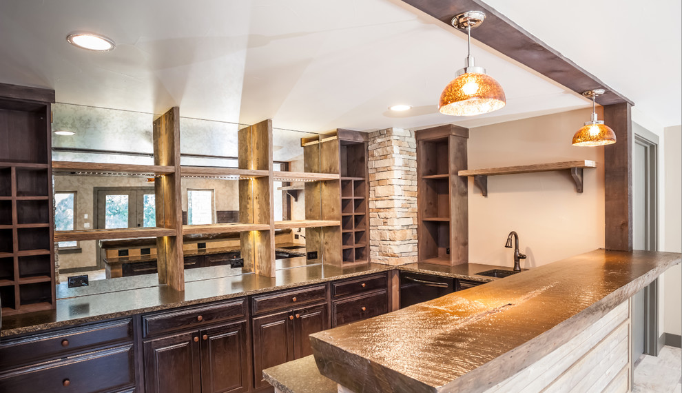 Photo of a large transitional galley seated home bar in Minneapolis with an undermount sink, raised-panel cabinets, dark wood cabinets, wood benchtops, glass sheet splashback and porcelain floors.