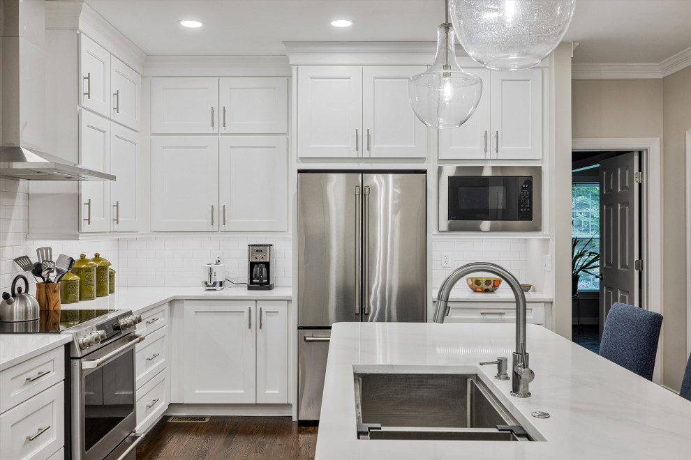 Large minimalist u-shaped dark wood floor and brown floor eat-in kitchen photo in Richmond with an undermount sink, shaker cabinets, white cabinets, quartzite countertops, white backsplash, ceramic backsplash, stainless steel appliances, an island and white countertops