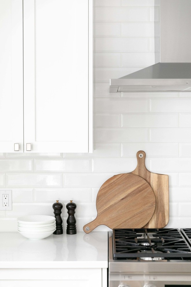 Eat-in kitchen - large transitional u-shaped medium tone wood floor and brown floor eat-in kitchen idea in Calgary with an undermount sink, shaker cabinets, white cabinets, quartzite countertops, white backsplash, subway tile backsplash, stainless steel appliances, an island and white countertops