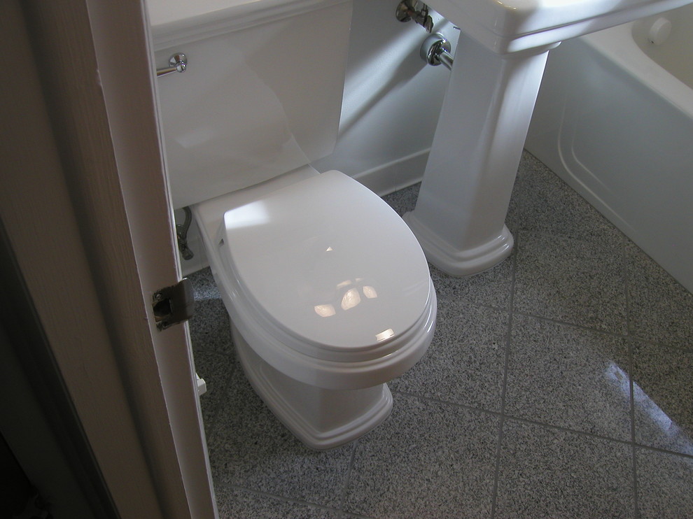 This is an example of a small contemporary kids bathroom in Denver with a pedestal sink, a corner tub, a two-piece toilet, gray tile, porcelain tile, white walls and porcelain floors.