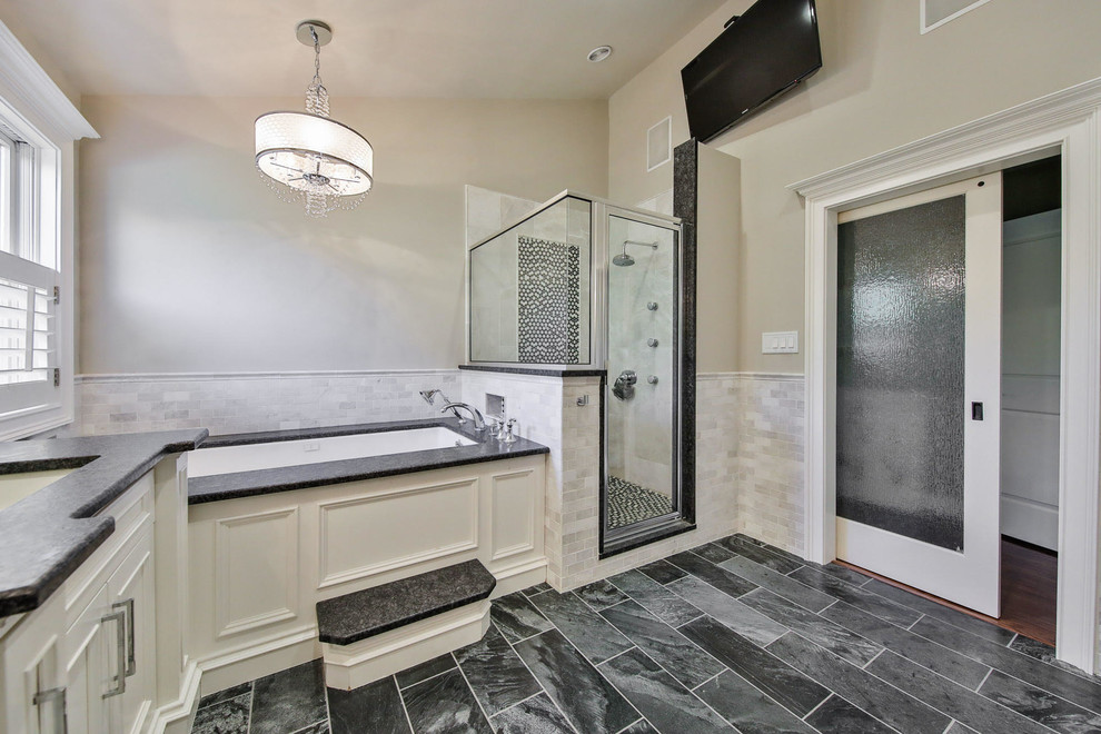 Inspiration for a large transitional master bathroom in Other with beaded inset cabinets, white cabinets, an undermount tub, a corner shower, gray tile, marble, beige walls, an undermount sink, granite benchtops, grey floor, a hinged shower door and black benchtops.