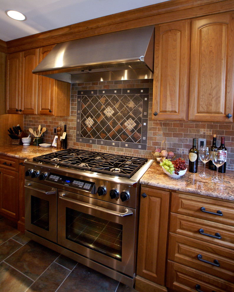 Photo of a mid-sized traditional kitchen in Newark with raised-panel cabinets, dark wood cabinets, granite benchtops, multi-coloured splashback, stone tile splashback, stainless steel appliances and ceramic floors.