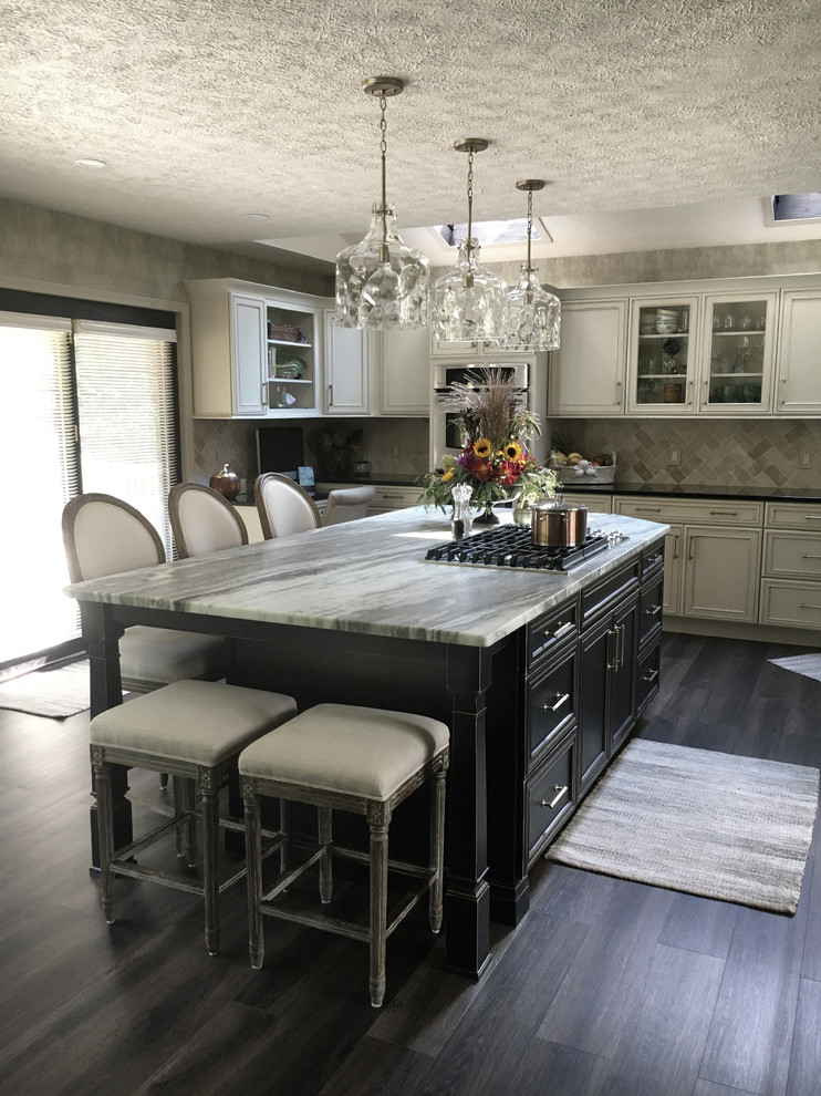 Inspiration for a large transitional u-shaped laminate floor and gray floor eat-in kitchen remodel with an undermount sink, recessed-panel cabinets, white cabinets, granite countertops, white backsplash, ceramic backsplash, stainless steel appliances, an island and black countertops