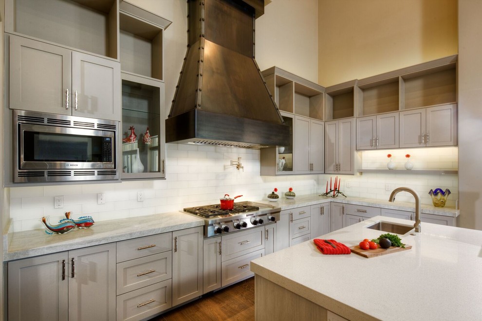 Large transitional u-shaped medium tone wood floor eat-in kitchen photo in Sacramento with a farmhouse sink, solid surface countertops, white backsplash, subway tile backsplash, stainless steel appliances, an island, shaker cabinets and beige cabinets