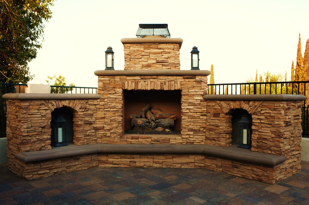This is an example of a large traditional backyard patio in Orange County with a fire feature, natural stone pavers and no cover.