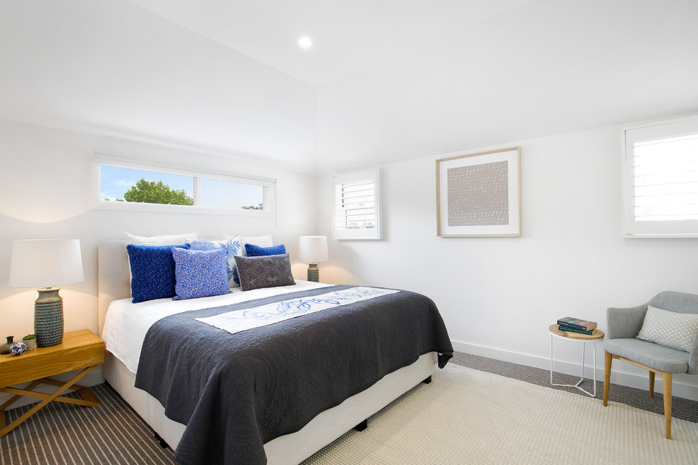 Photo of a midcentury master bedroom in Sydney with white walls, carpet, no fireplace and multi-coloured floor.